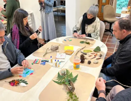 Pessoas sentadas à mesa trabalhando com elementos naturais