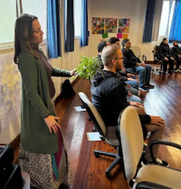 Facilitadora segurando uma planta enquanto fala para o grupo