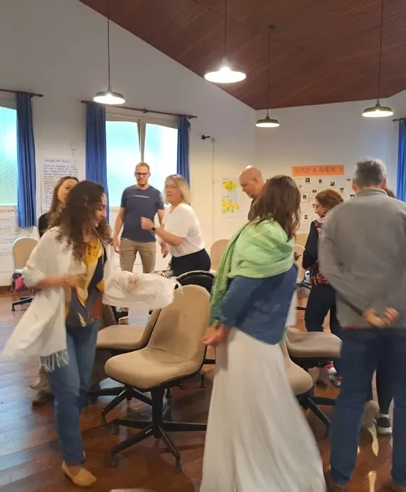 Integrantes em pé participando de uma dinâmica
