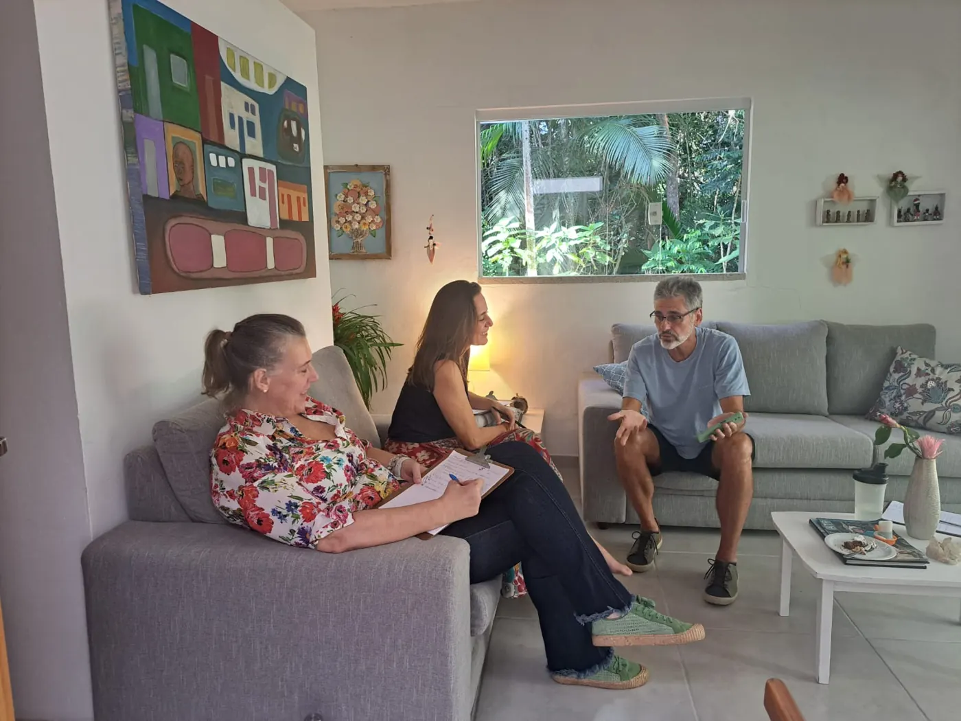 Três participantes conversando em sofás
