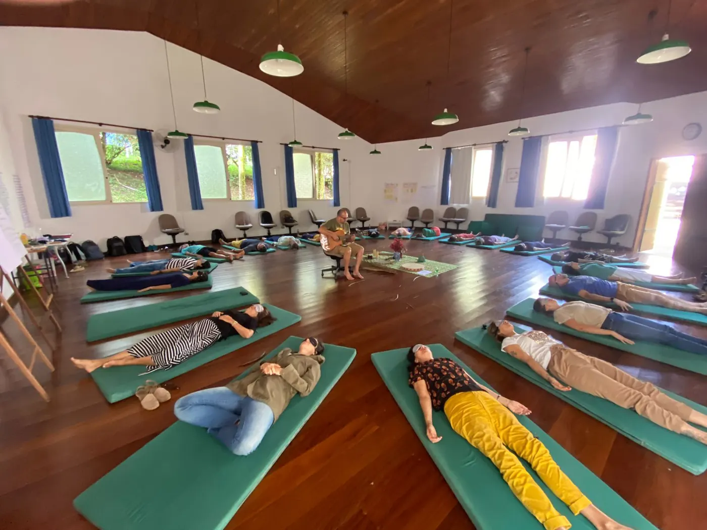 Grupo deitado em círculo em atividade de relaxamento
