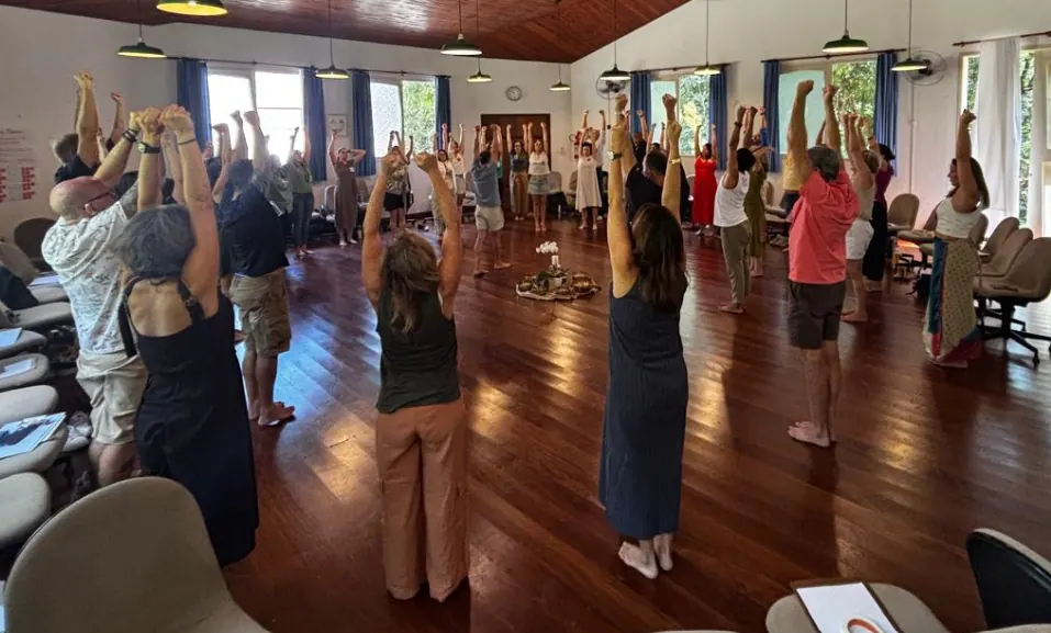 Grupo em pé em círculo com os braços levantados