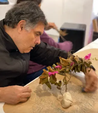 Integrante trabalhando com argila e galhos secos