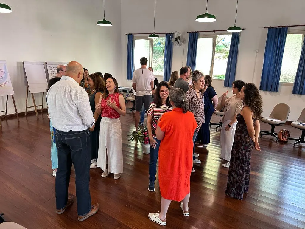 Grupo em roda trocando ideias no salão de madeira