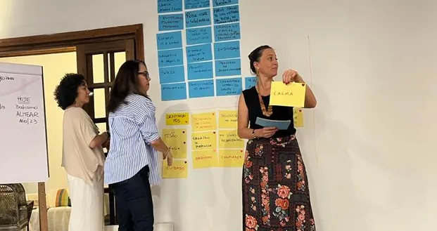 Duas integrantes apresentando cartazes para o grupo