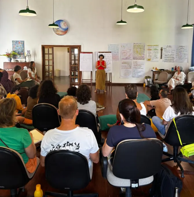 Integrante apresentando para o grupo sentado em sala clara